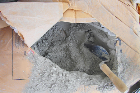 close up trowel in a bag of cement powder