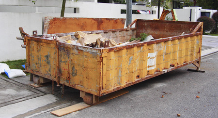 Yellow construction rubbish bin with loads, home renovationの写真素材