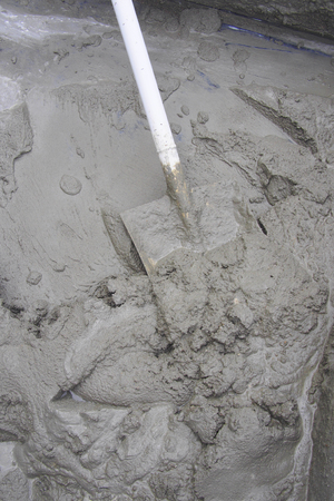 mixing cement with a shovel in a tubの写真素材