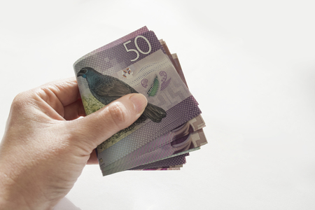 Woman holding a stack of New Zealand currencyの写真素材