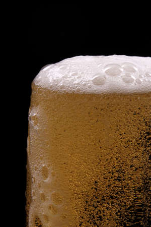 A glass of beer against black background 