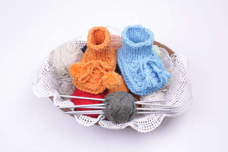 Close look on woollen baby shoes in a basketの写真素材
