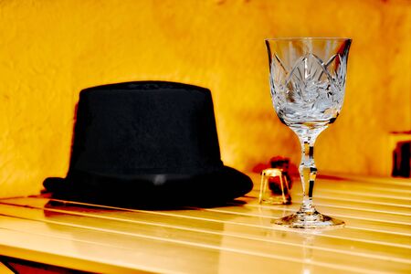 Black hat and crystal glass on an orange backgroundの写真素材