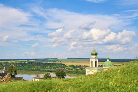 Beautiful church in a green field by the riverの写真素材