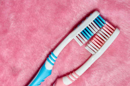 Two toothbrushes on a pink fluffy towelの写真素材