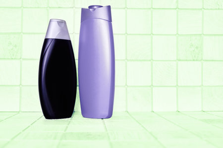 Two plastic bottles for detergents against the background of soft green squaresの写真素材