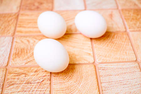 Three eggs on a pink wooden checkered backgroundの写真素材