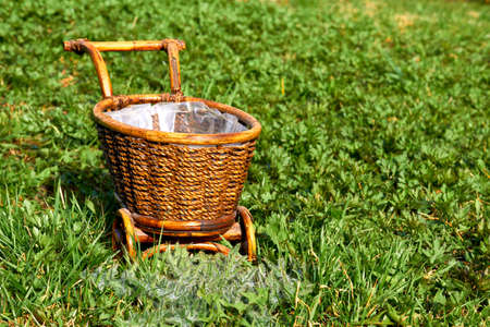 Wooden wicker brown cart in a garden on a green lawnの写真素材
