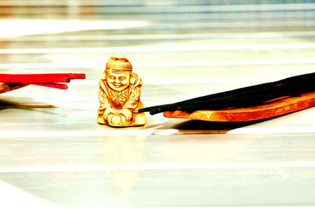 Gold buddha figurine and an incense on white tableの写真素材