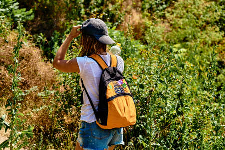 Young athletic woman goes on a wellness summer hike among thickets of bushesの写真素材