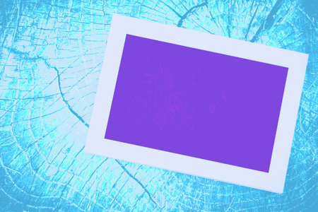 Purple screen neon and white frame TV monitor on an azure blue wooden wallの写真素材