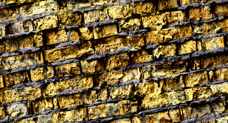 Big full background of detailed old dark yellow brick wallの写真素材
