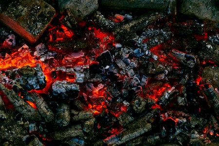 Campfire with fading flame and smoldering coals. Time for cooking meat.