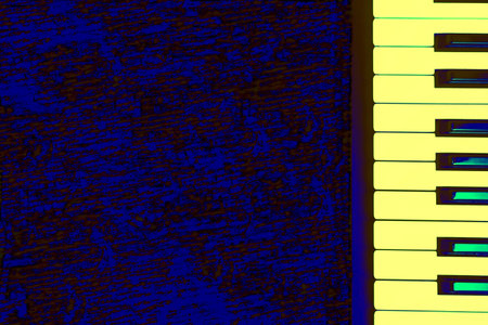 Yellow green musical synthesizer piano keys on a dark blue surface for textの写真素材