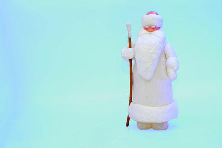 Santa claus with staff in white fur coat isolated on snow blueの写真素材