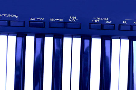 Blue keys and control panel synthesizer with auto accompaniment on white