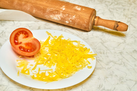 Wooden rolling pin for dough, tomato and grated cheese, cooking pizzaの写真素材
