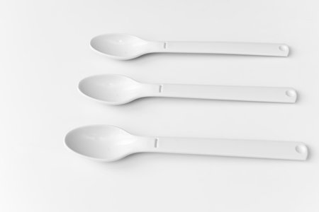 White plastic spoons for camping, isolated on white surfaceの写真素材
