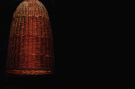 Woven straw lampshade for lighting with an electric lamp in the dark