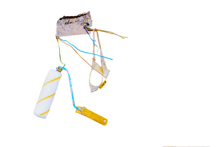 construction, repair. Hole in wall for electric switch socket with paint rollerの写真素材