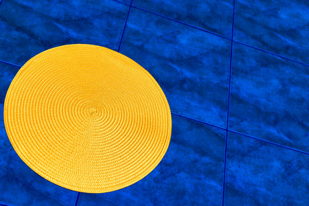 Yellow spiral around a straw background on blue tile