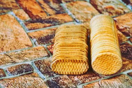Delicious sweet cookies in a protective cellophane package on brown red bricks
