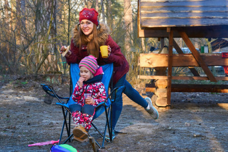 Satisfied mother with a child on a picnic in the forest, in a recreation areaの写真素材