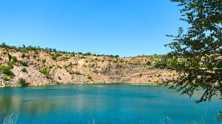 Old abandoned quarry lake filled with emerald water with radon