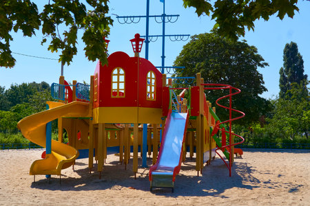 Summer spring children's playground with painted toy slide in park