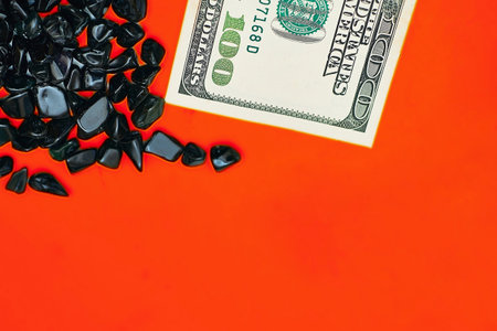 Money. 100 dollars banknotes on red. Black gemstonesの写真素材