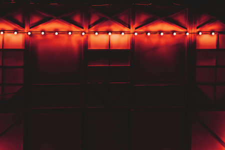 Dark draped glowing decorated wall with red orange backlightの写真素材