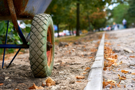 Road repair.Wheel of a metal construction wheelbarrow,pedestrian path