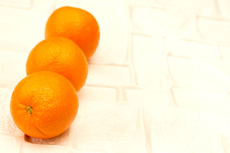 a round juicy citrus fruit with a tough bright reddish-yellow rindの写真素材