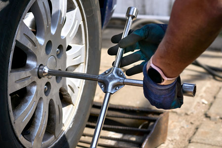 Replacing a car wheel at a tire station. a rubber covering, typically inflated or surrounding an...