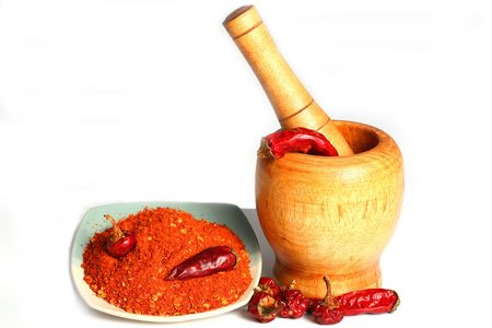 Red hot dry and ground peppers on the table with mortarの写真素材