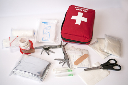Open first aid kit with bandages, scissors, \"triangle scarf\", syringe, plaster, knife, tools, gauze, etcのeditorial素材