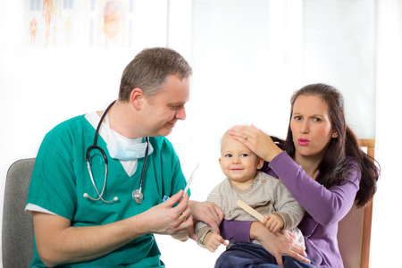 doctor measures the temperature of the babyの写真素材