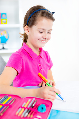 Smiling Caucasian girl doing homework at home の写真素材