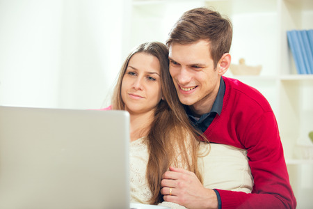 Young couple relaxing on sofa with laptop in the living room.Selective focusの写真素材