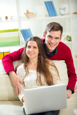 Young couple relaxing on sofa with laptop in the living room.Selective focusの写真素材