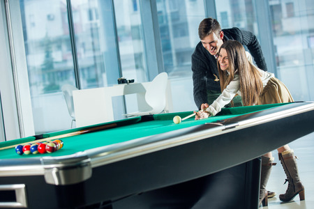 Beautiful couple standing next to the pool table, selective focus