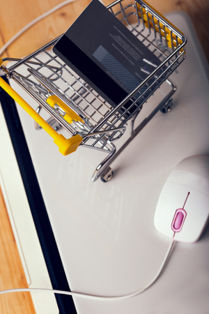 Shopping trolley sitting on close laptop,credit card in a supermarket trolleyの写真素材