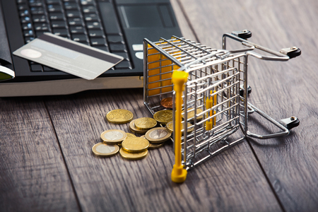 Credit card on a laptop, from supermarket trolleys dropped coinsの写真素材