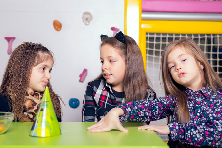 Smiling little girl with her friends at birthday partyの写真素材