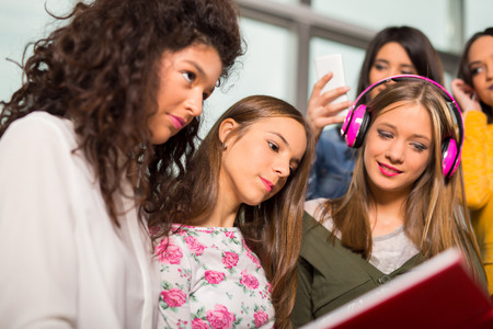 Teenager girls hanging out together in a coffee shopの写真素材
