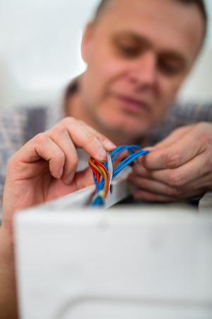 Technician repairing a washing machine, close up of wire supplyの写真素材