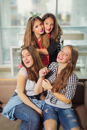 Portrait of four young women sitting at the table in the cafe, selective focusの写真素材