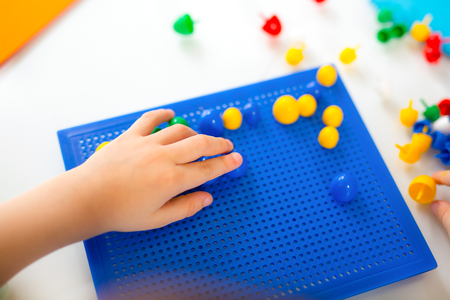 Kid playing with educational toys on a tableの写真素材