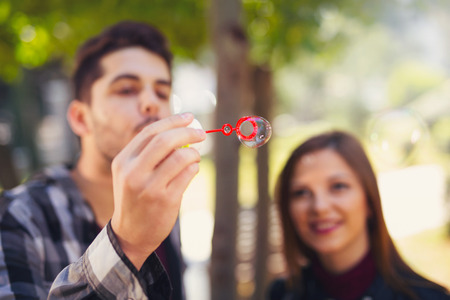 Couple Relaxing in the Park with bubble blower. Spring time.の写真素材