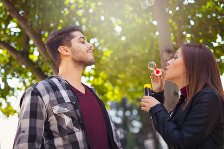 Couple Relaxing in the Park with bubble blower. Spring time.の写真素材